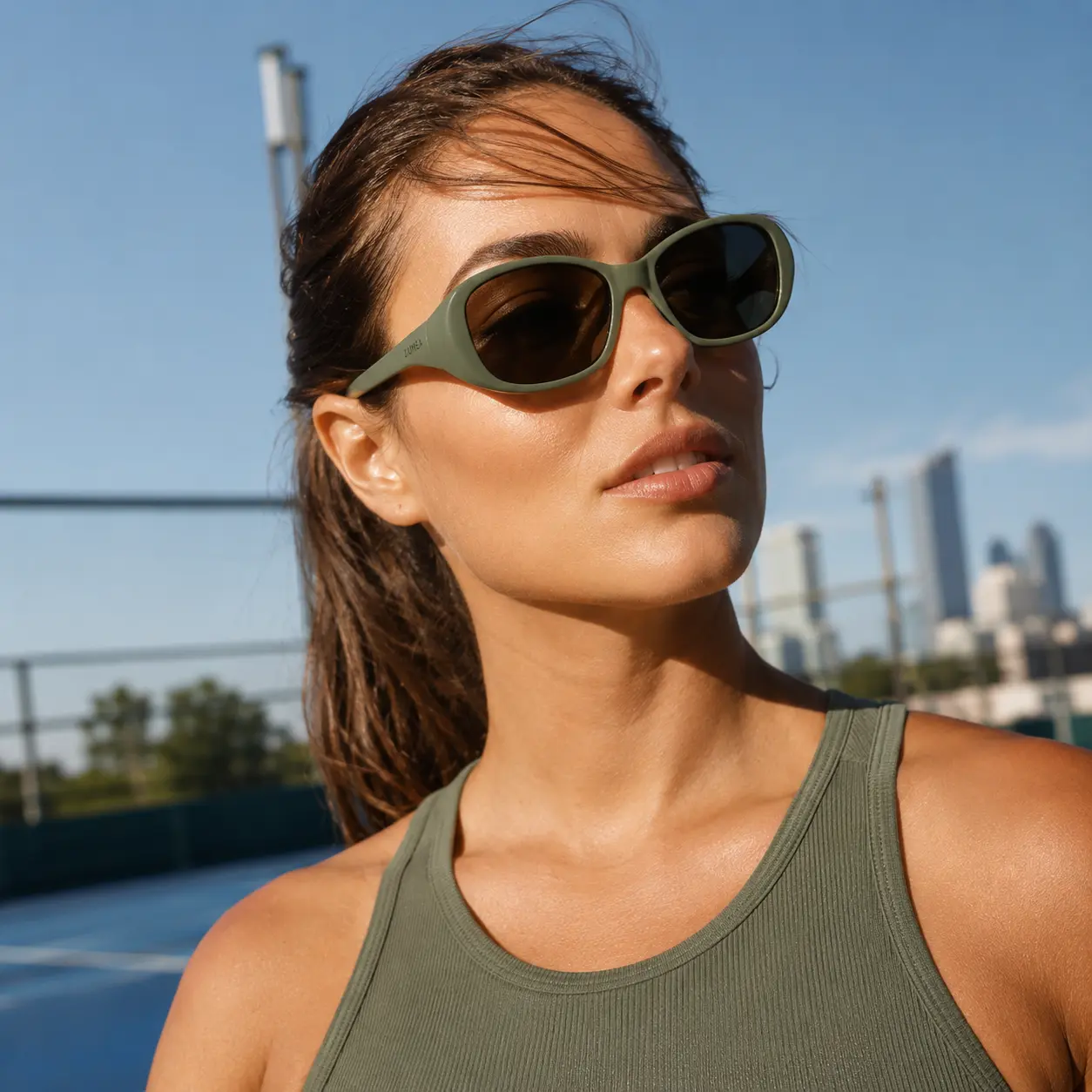 Campaign photo of the sage sunglasses worn by a model on an outdoor court