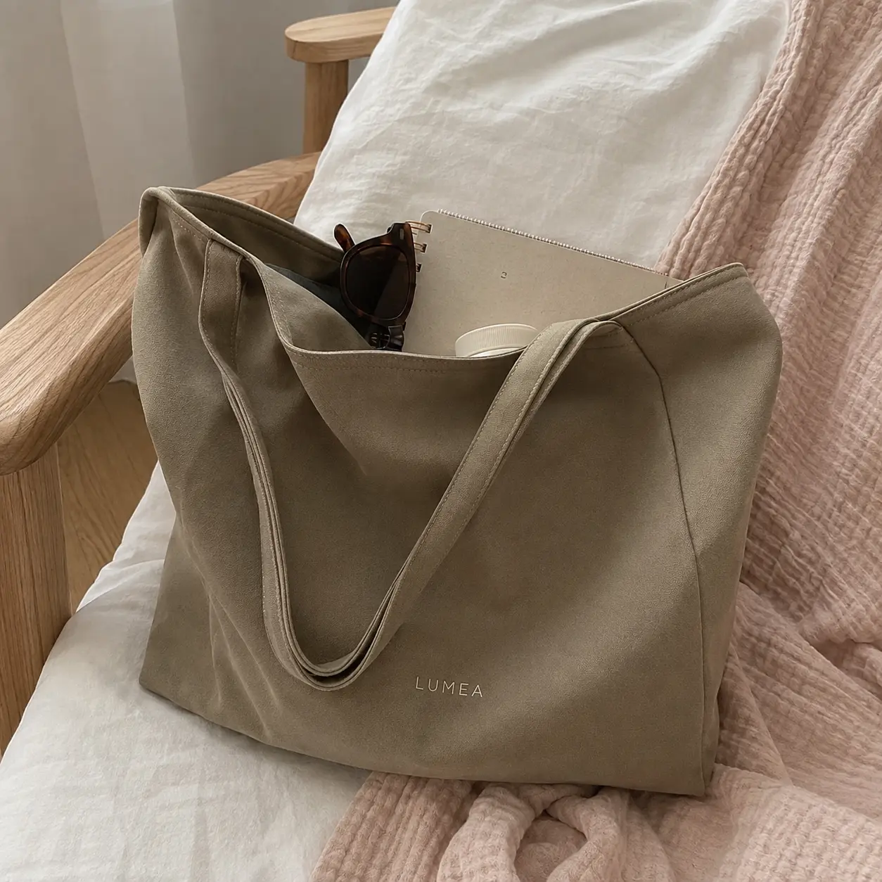 Phone photo of a suede tote bag on an armchair